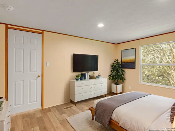 a bedroom with a bed and a flat screen tv