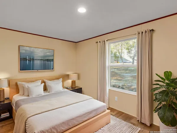 a bedroom with a large bed and a potted plant