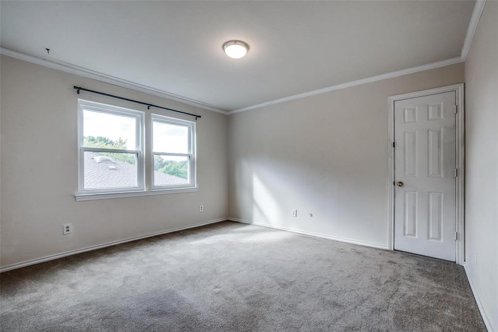 9911 Silver Creek Road Dallas, TX 75243 - Photo 24 of 28 Neutral-toned walls with crown molding, plush gray carpet, a two-panel window, and a white paneled door