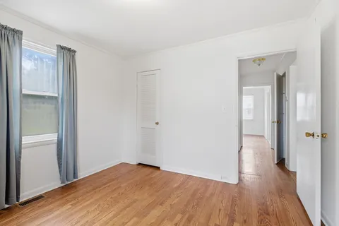 a view of a room with wooden floor and a bathroom