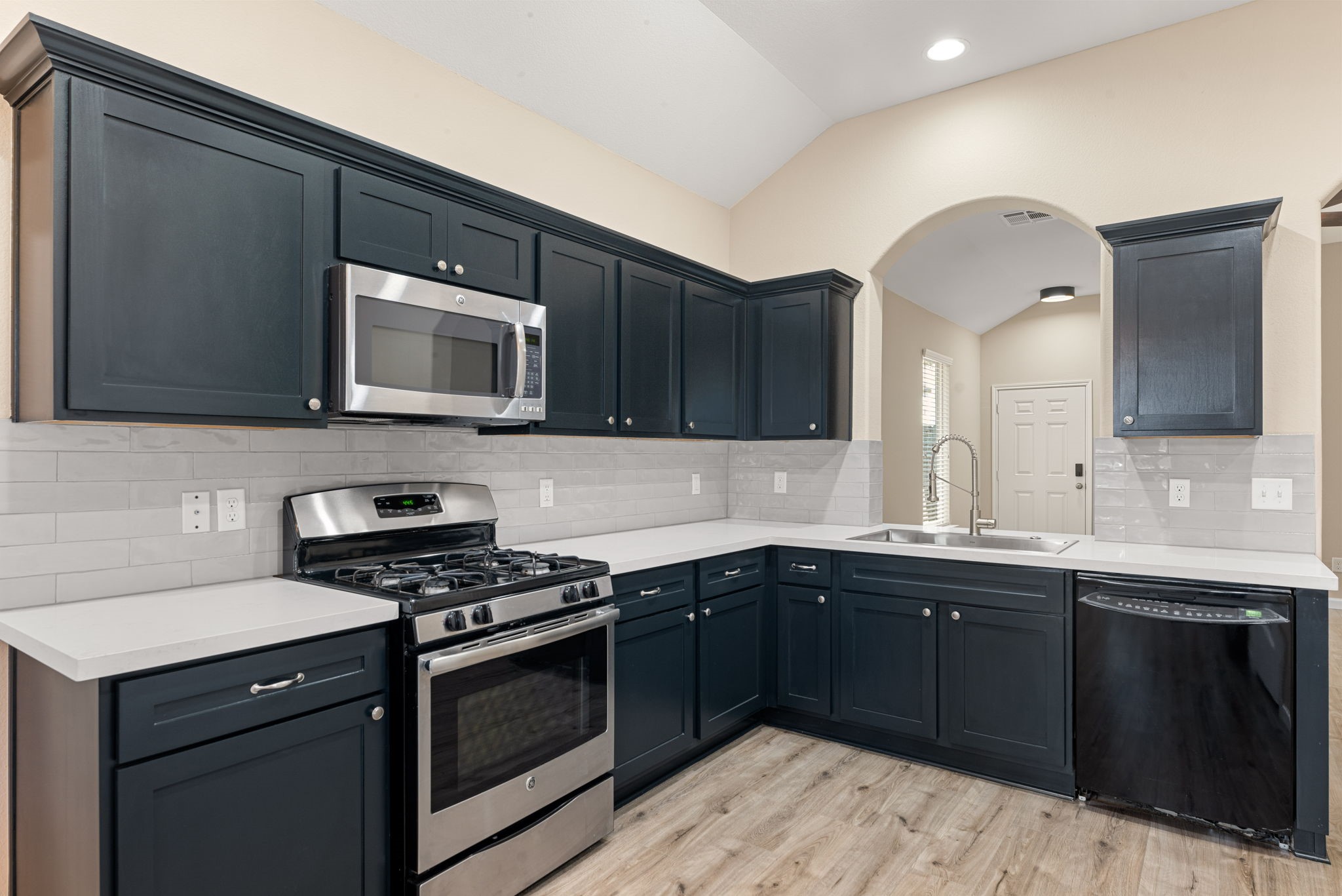 11429 West Woodmark Conroe, TX 77304 - Photo 11 of 29 a kitchen with a sink stove and microwave