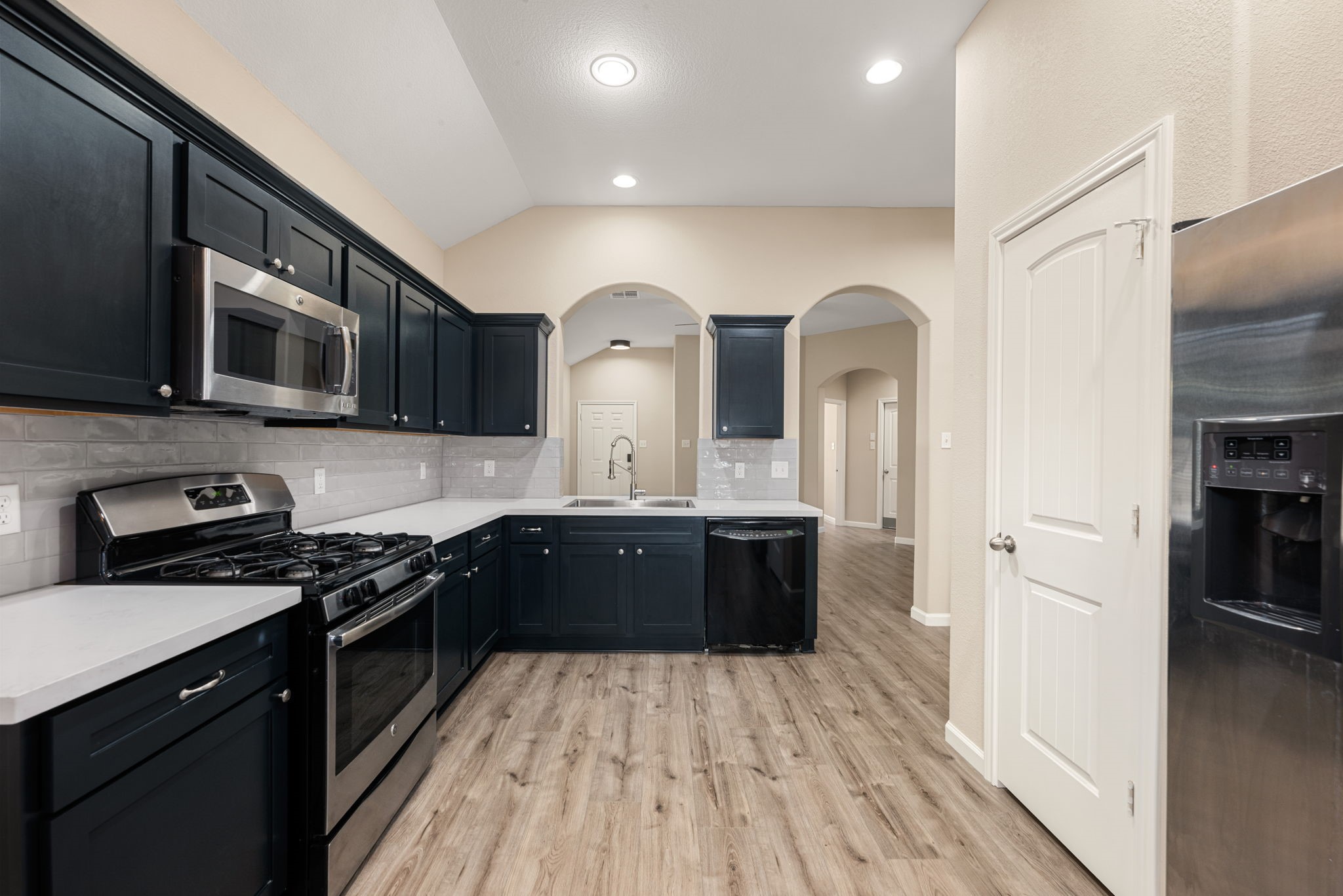 11429 West Woodmark Conroe, TX 77304 - Photo 12 of 29 a kitchen with stainless steel appliances granite countertop a stove a sink and a refrigerator