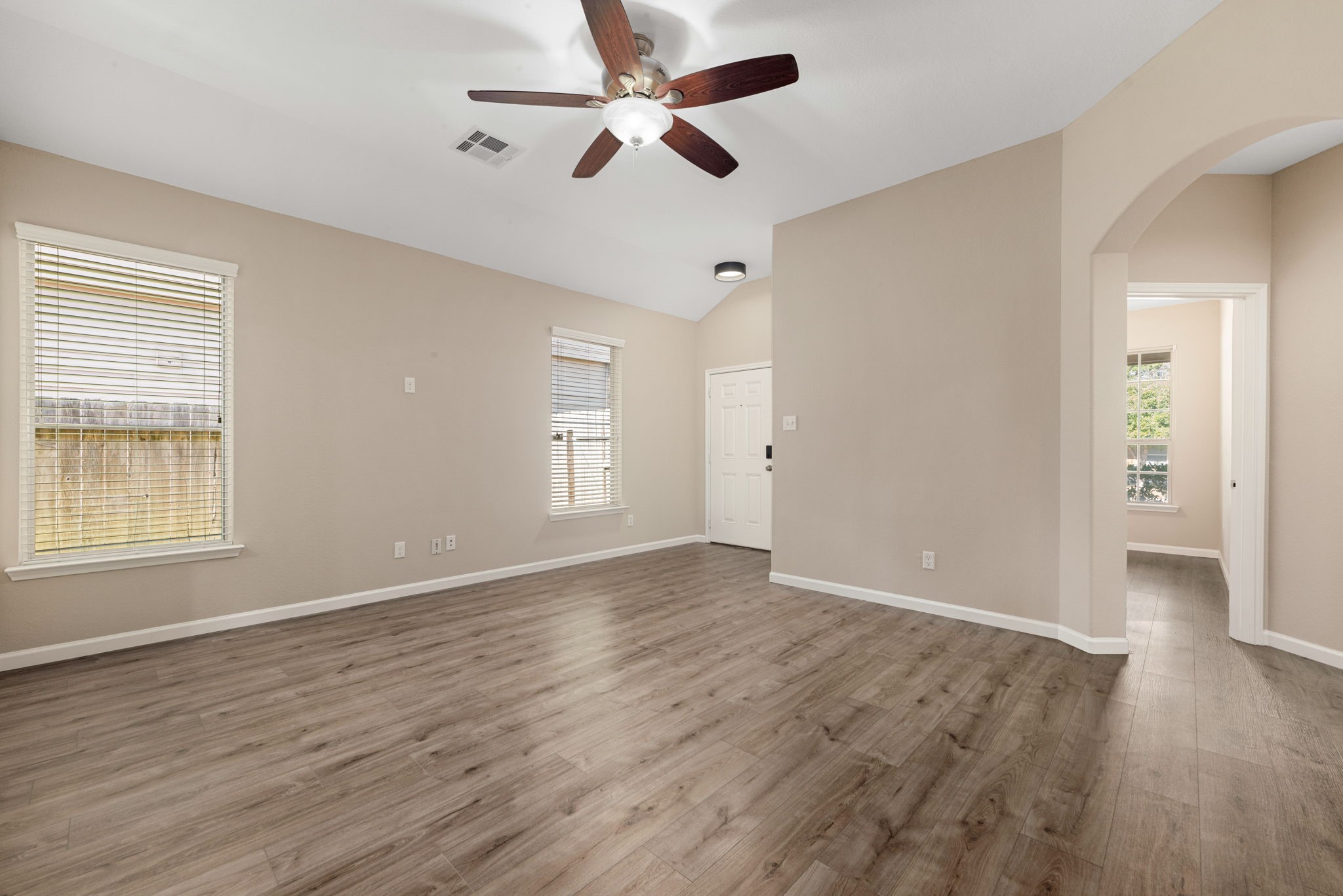 11429 West Woodmark Conroe, TX 77304 - Photo 8 of 29 an empty room with wooden floor ceiling fan and windows