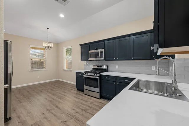 a kitchen with a sink stove and microwave