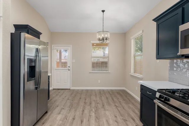 a kitchen with stainless steel appliances granite countertop a stove and a wooden floors