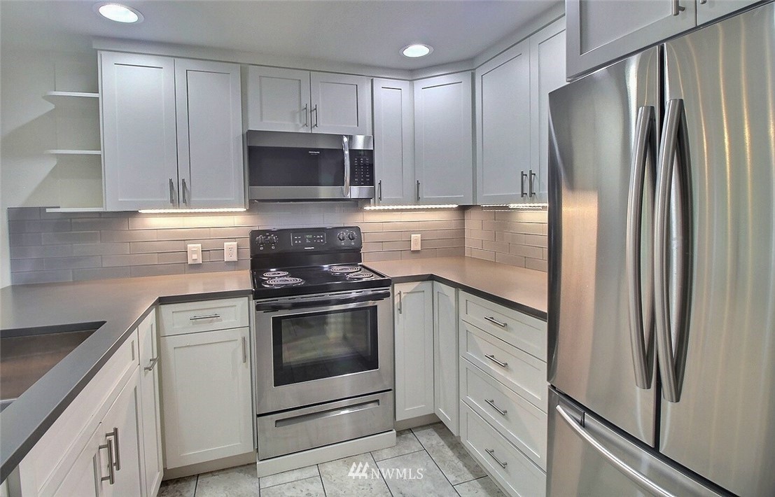 19404 Bothell Way Northeast, Unit B304 Bothell, WA 98011 - Photo 7 of 38 a kitchen with white cabinets stainless steel appliances and a counter space