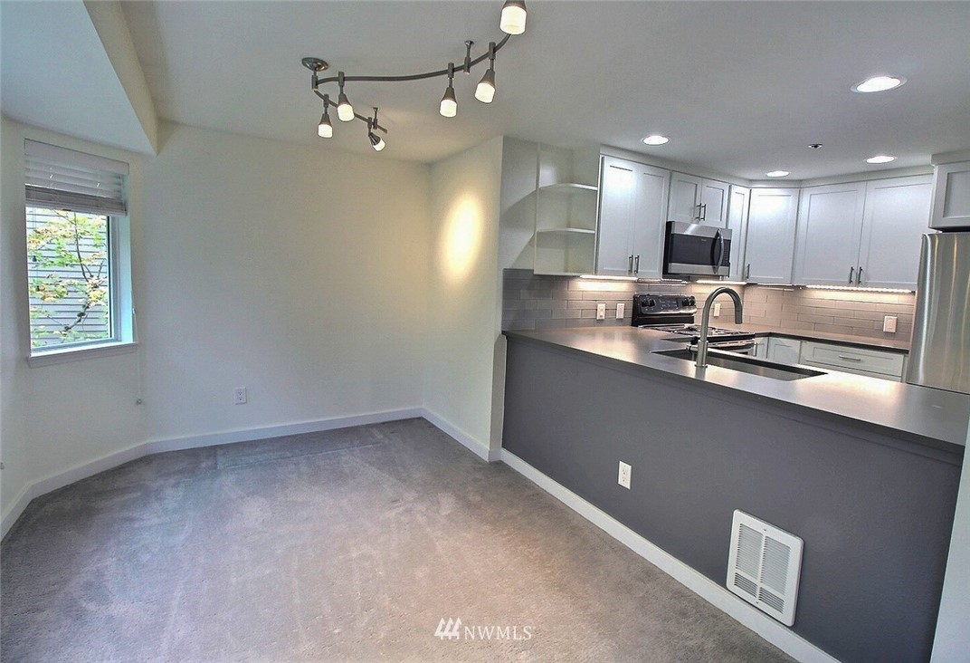 19404 Bothell Way Northeast, Unit B304 Bothell, WA 98011 - Photo 10 of 38 an open kitchen with kitchen island white cabinets and stainless steel appliances