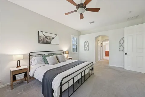 a bedroom with a large bed and a chandelier