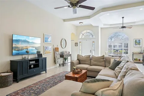 a living room with furniture a chandelier and a large window