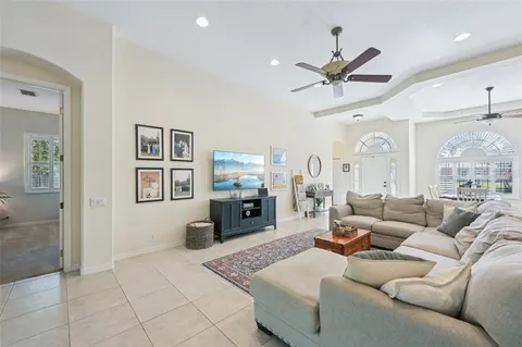 a living room with furniture a chandelier and a view of kitchen