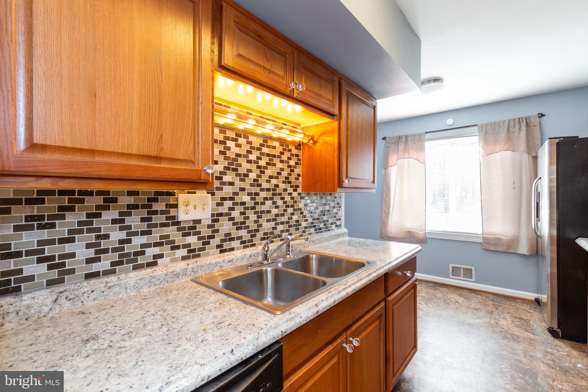 32 Bristol Court Stafford, VA 22556 - Photo 7 of 25 a kitchen with granite countertop a sink and a refrigerator