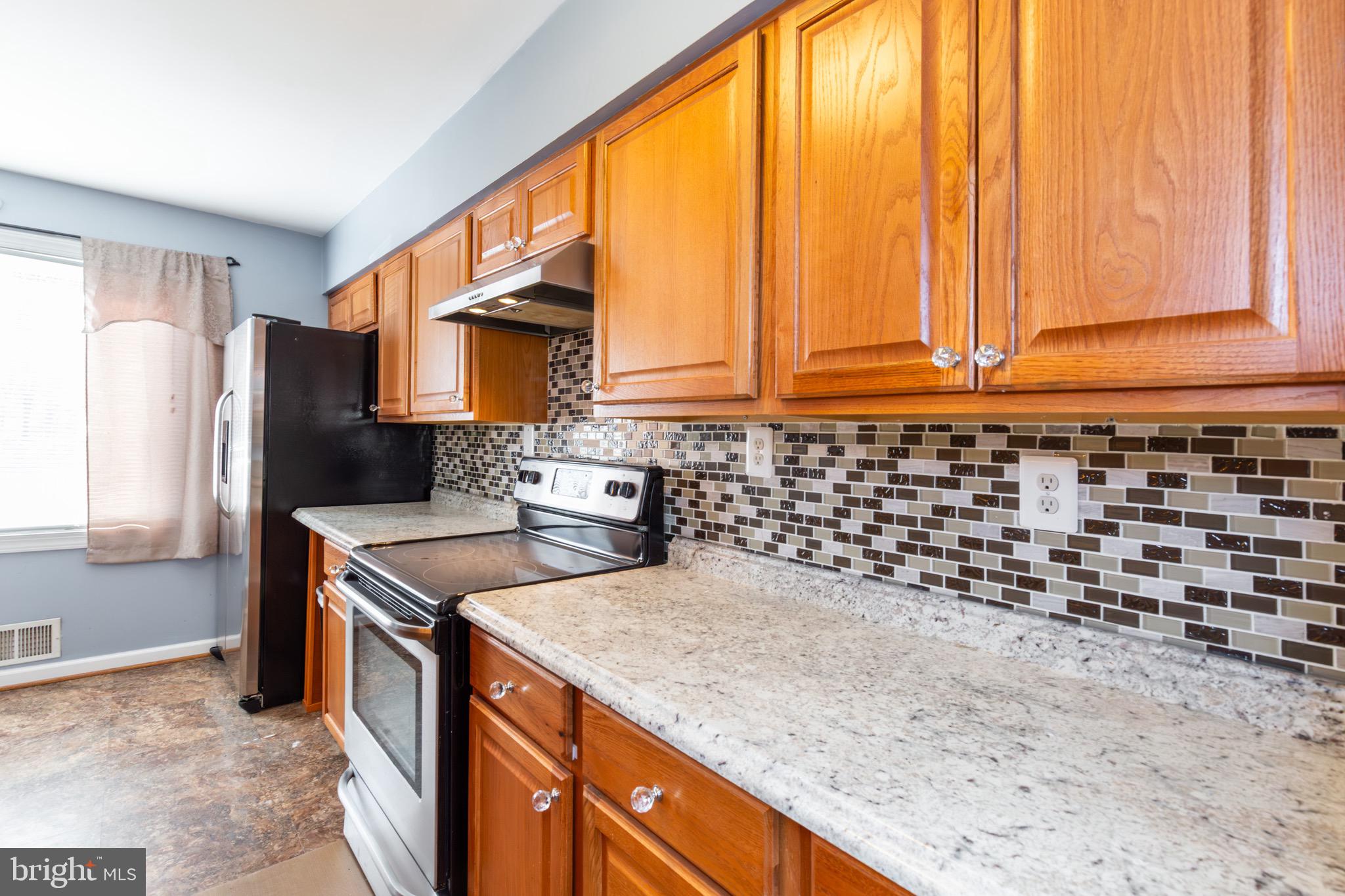 32 Bristol Court Stafford, VA 22556 - Photo 8 of 25 a kitchen with stainless steel appliances granite countertop a sink a stove and a refrigerator