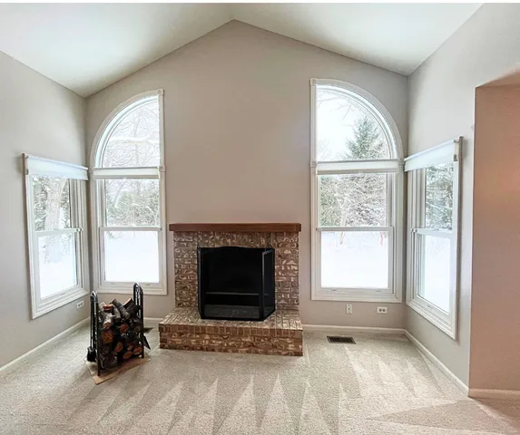 a living room with fireplace and a window
