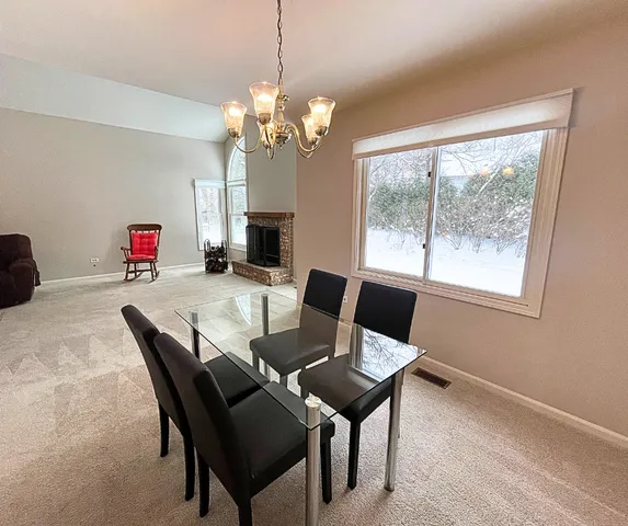 a view of a dining room with furniture a chandelier and window