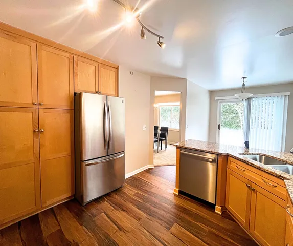 a kitchen with stainless steel appliances a refrigerator sink and wooden floor