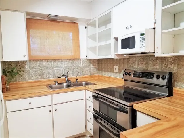a kitchen with stainless steel appliances granite countertop a sink and a stove