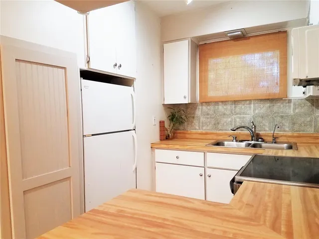 a kitchen with a refrigerator a stove a sink and a window