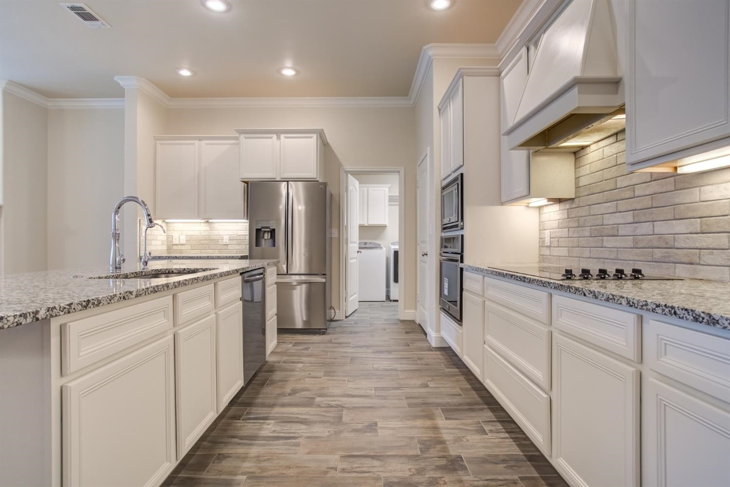 8806 Rochester Avenue Lubbock, TX 79424 - Photo 6 of 25 a large kitchen with kitchen island granite countertop a sink and stainless steel appliances