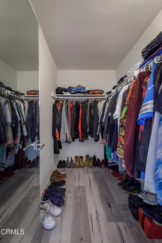 a view of walk in closet with clothes and shoes