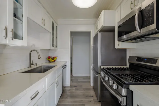 a kitchen with stainless steel appliances granite countertop a sink a stove and a microwave