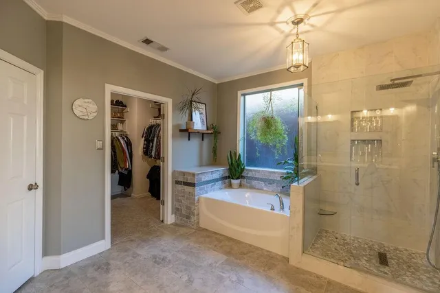 a spacious bathroom with a glass shower door and a bathtub