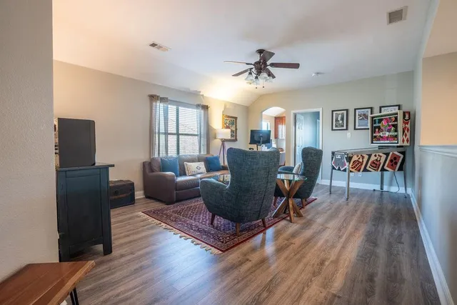 a living room with furniture and a wooden floor