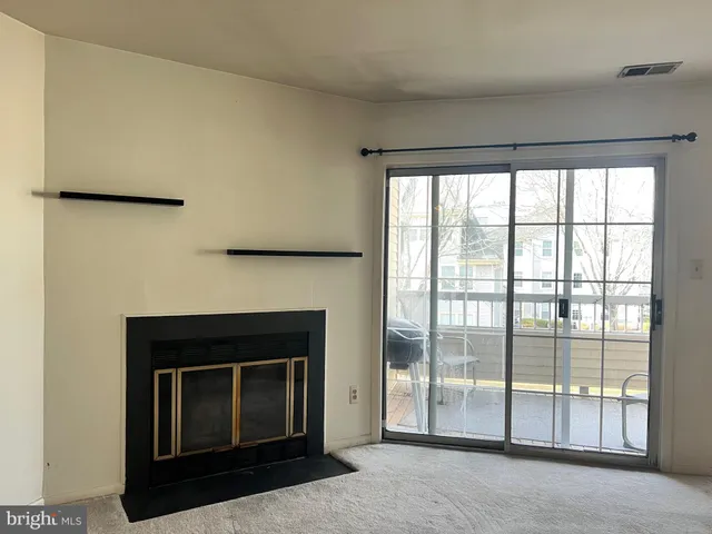 a living room with a fireplace and a floor to ceiling window