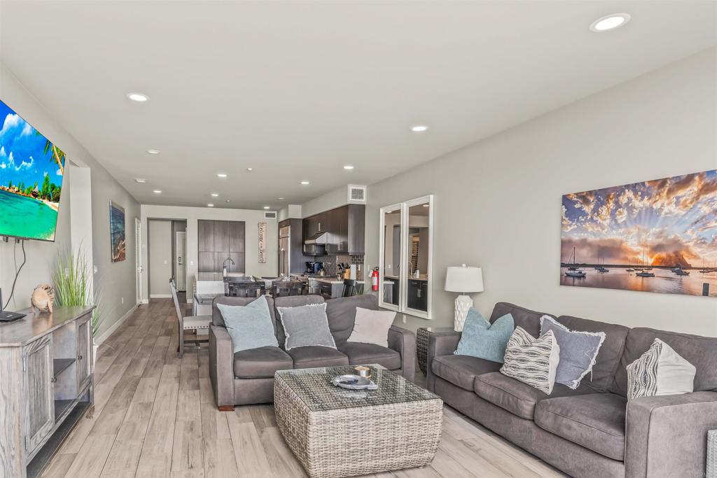 700 South The Strand, Unit 102 Oceanside, CA 92054 - Photo 12 of 25 a living room with furniture and a wooden floor
