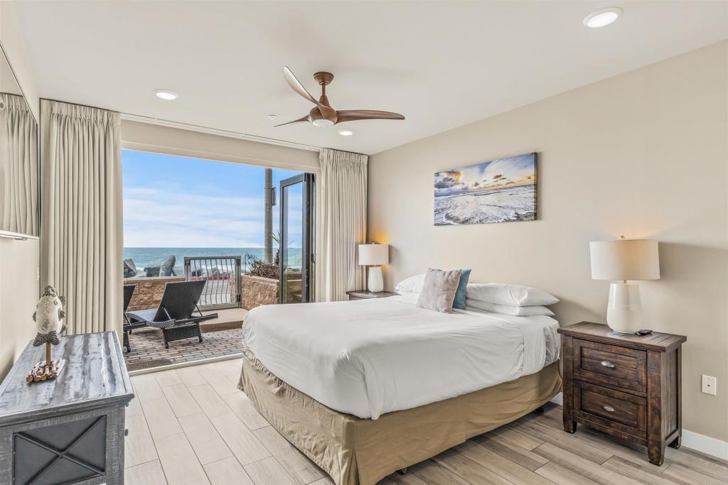 700 South The Strand, Unit 102 Oceanside, CA 92054 - Photo 15 of 25 a bedroom with a large bed and a chandelier