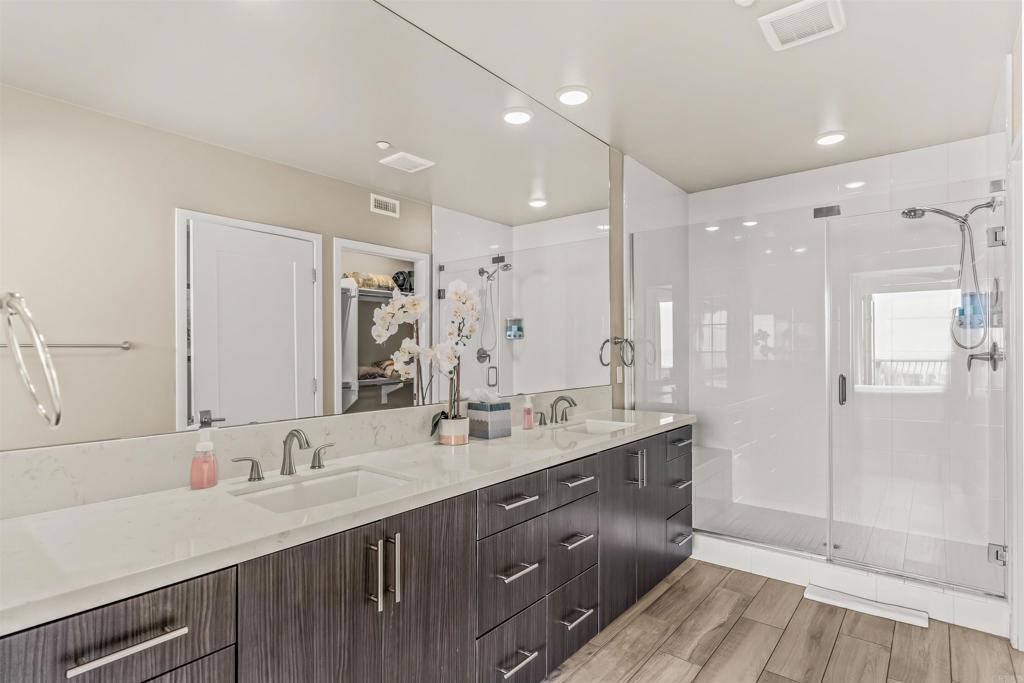 700 South The Strand, Unit 102 Oceanside, CA 92054 - Photo 17 of 25 a bathroom with a double vanity sink mirror and shower