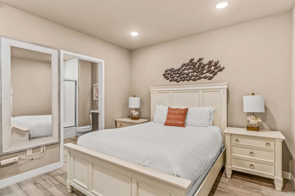 700 South The Strand, Unit 102 Oceanside, CA 92054 - Photo 18 of 25 a bedroom with a white bed and dresser