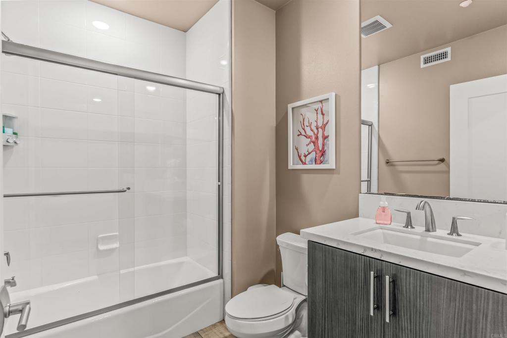 700 South The Strand, Unit 102 Oceanside, CA 92054 - Photo 20 of 25 a bathroom with a granite countertop sink toilet and shower