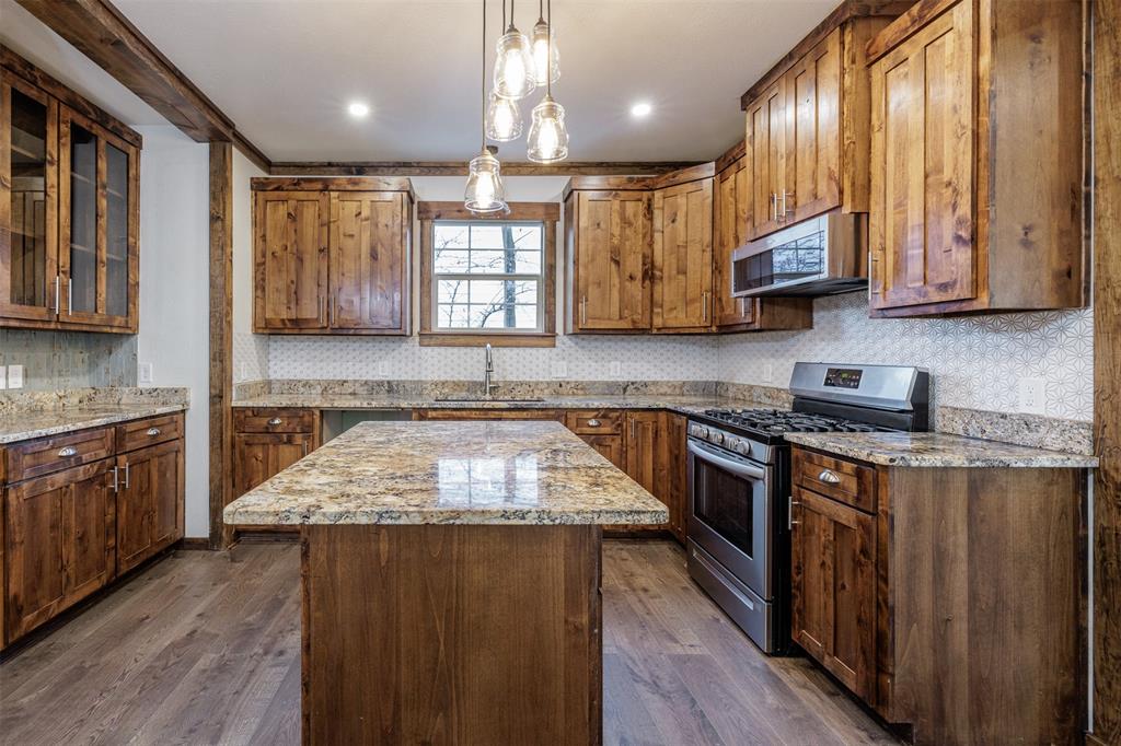 217 Houston Street Sulphur Springs, TX 75482 - Photo 14 of 35 a kitchen with stainless steel appliances granite countertop wooden cabinets a stove top oven a sink and dishwasher a oven with wooden floor