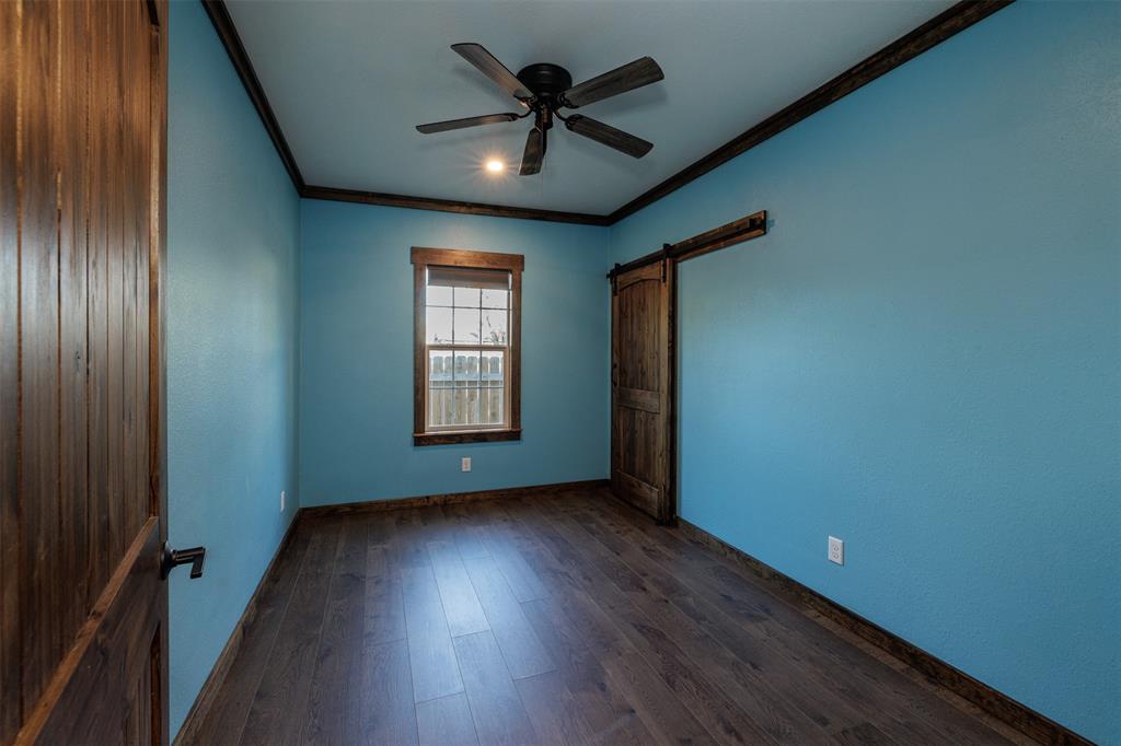 217 Houston Street Sulphur Springs, TX 75482 - Photo 20 of 35 an empty room with wooden floor and windows