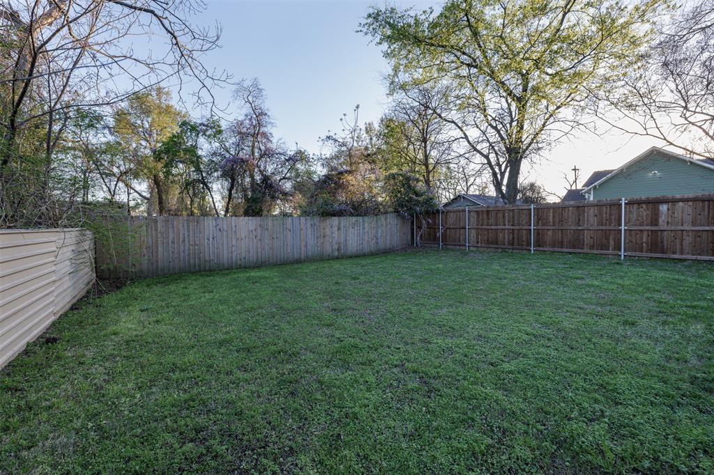 217 Houston Street Sulphur Springs, TX 75482 - Photo 24 of 35 a view of a backyard with a large tree and wooden fence