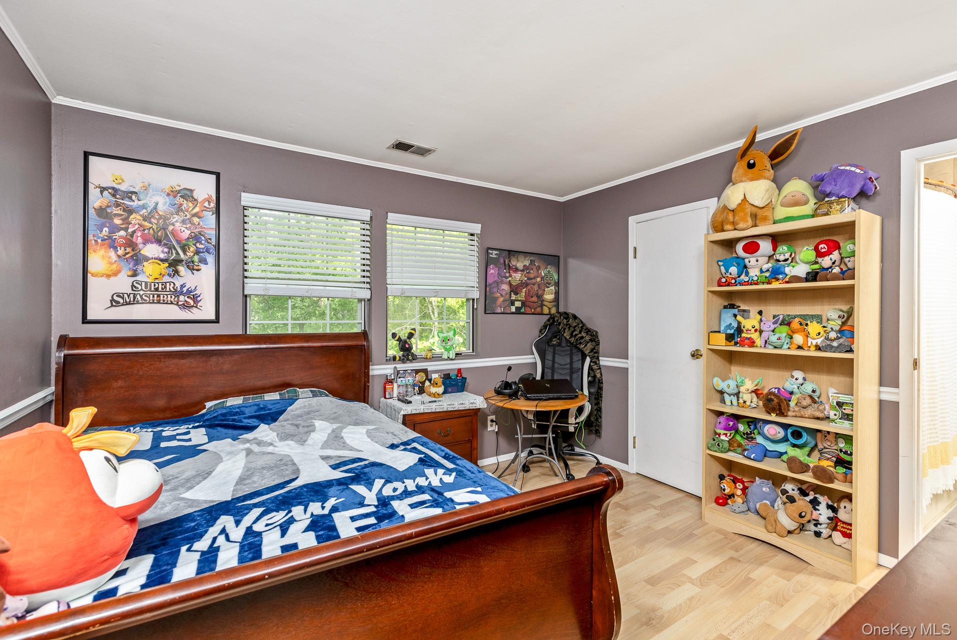 17 Stone Commons Yaphank, NY 11980 - Photo 19 of 31 Bedroom featuring wood-finish flooring, two windows with blinds, a white door, and a built-in shelving unit