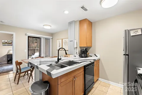 a kitchen that has a sink a table and chairs in it