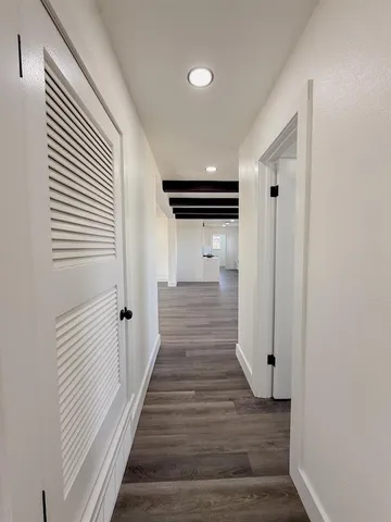a view of a hallway with wooden floor and staircase
