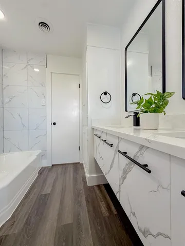 a bathroom with a bathtub and a potted plant