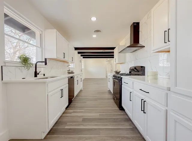 a kitchen with white cabinets and appliances