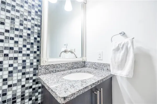 a bathroom with a granite countertop sink and a mirror