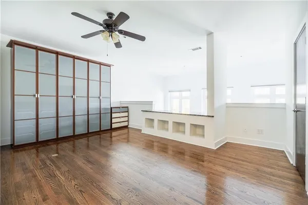 a view of an empty room with a window and wooden floor