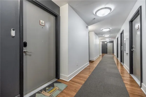a view of a hallway with wooden floor and a mirror