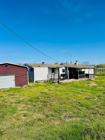 a backyard of a house with table and chairs