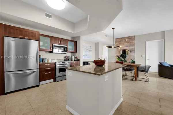 a kitchen with stainless steel appliances granite countertop a sink stove and refrigerator