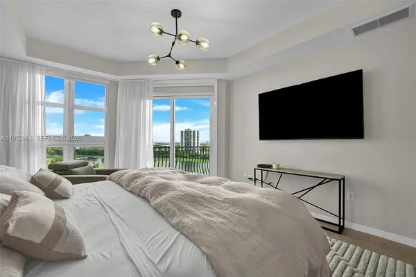 a bedroom with a large bed and a chandelier