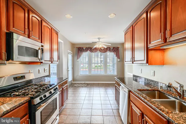 a kitchen with a sink stove top oven and glass door