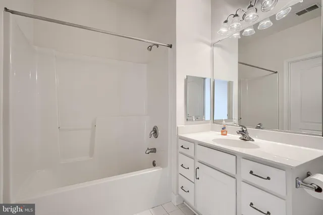 a bathroom with a double vanity sink mirror and shower