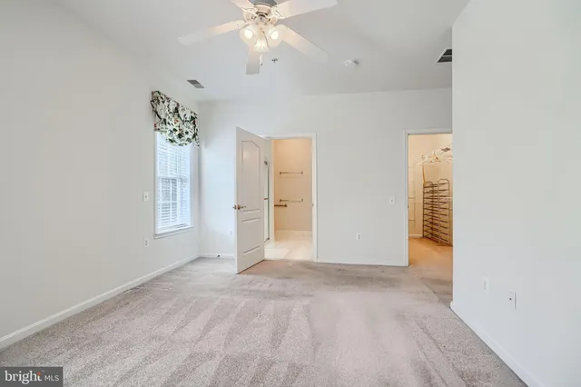 an empty room with a window and a fan