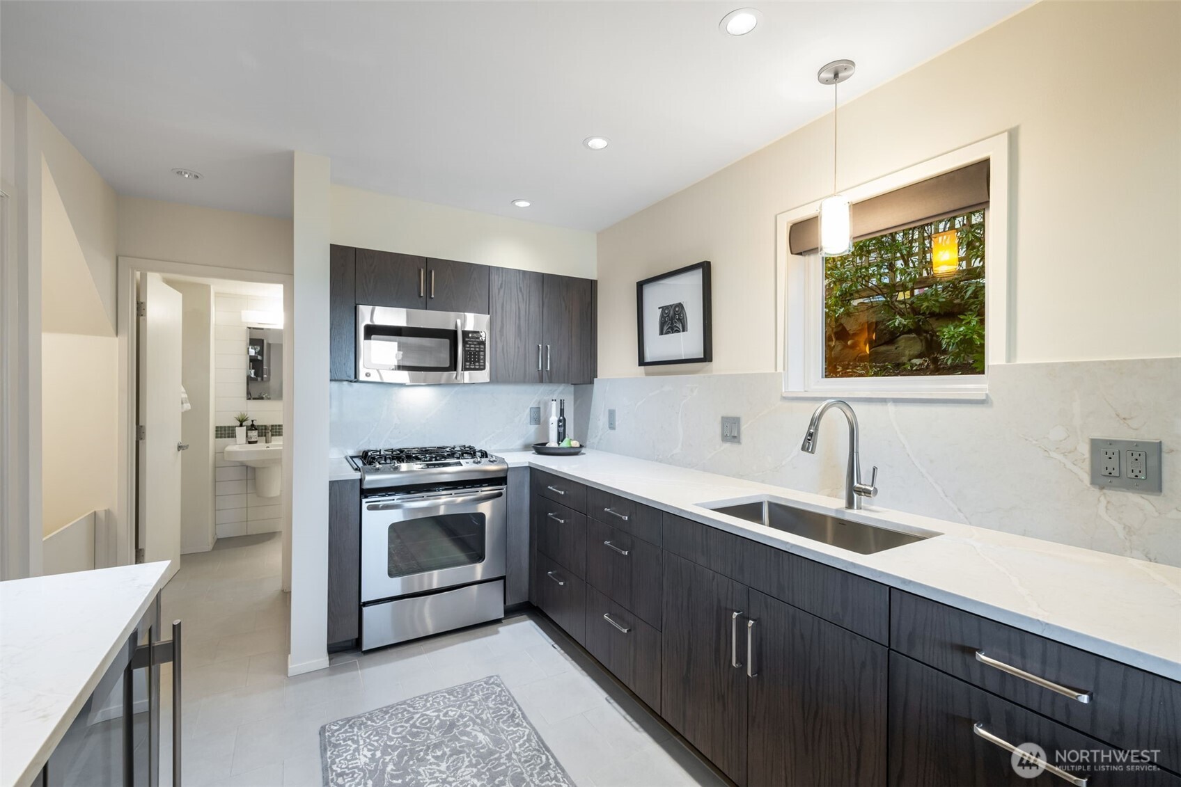 4017 56th Avenue Southwest Seattle, WA 98116 - Photo 29 of 39 a kitchen with stainless steel appliances granite countertop a sink stove and refrigerator